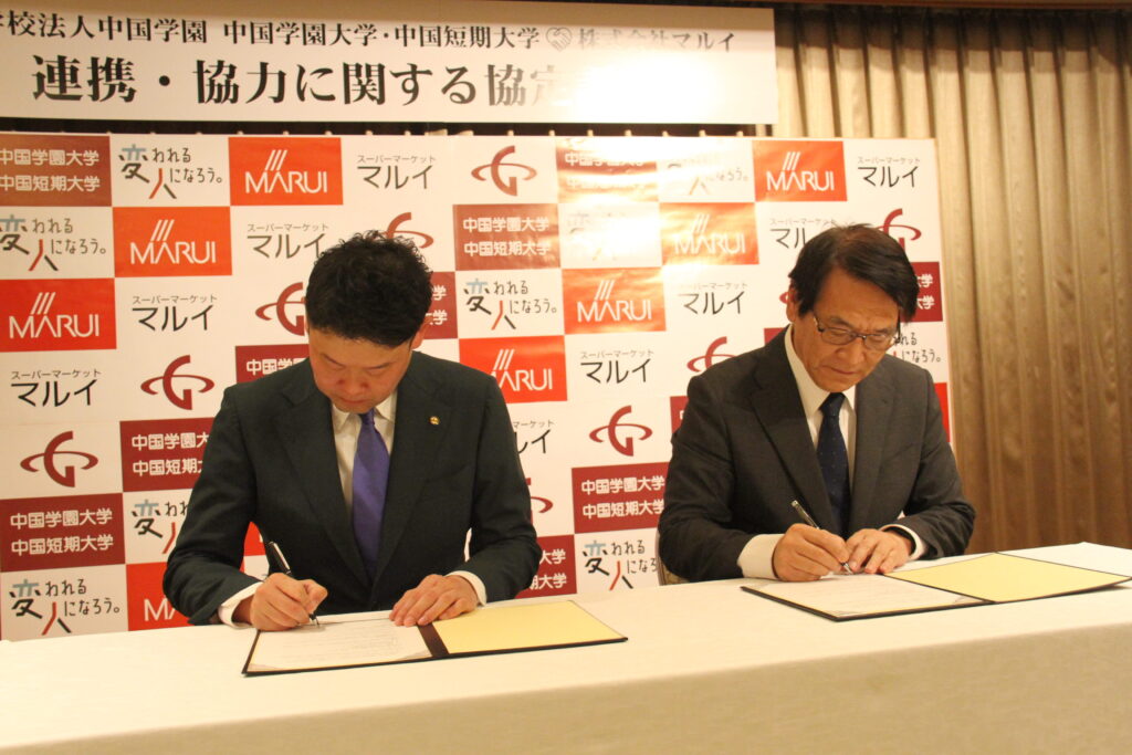 協定書に署名する松田社長（左）と加賀学長