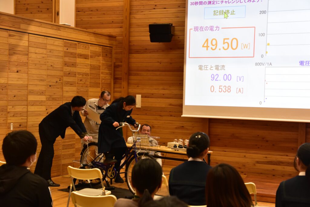 自転車発電機による発電に挑戦する中学生=岡山県英田郡西粟倉村影石のあわくら会館で