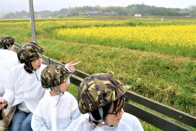自衛隊車両から菜の花畑を眺める家族連れら=岡山県奈義町で