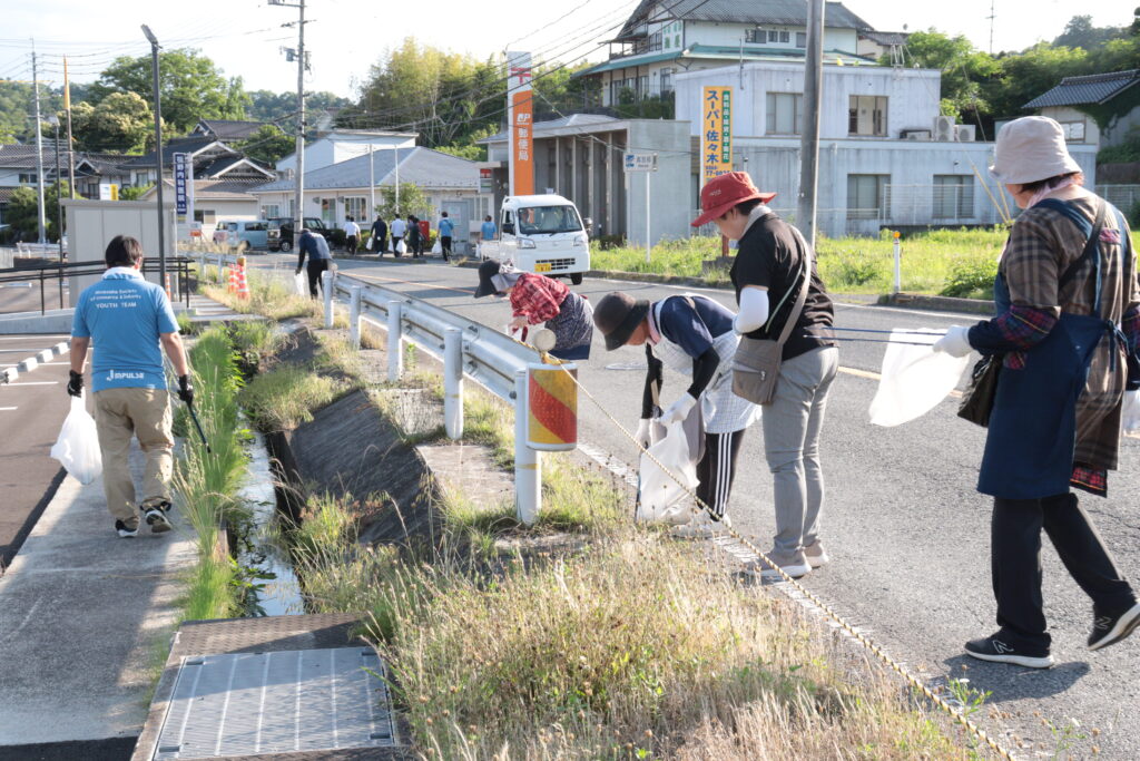 道沿いのごみを拾い集める参加者
