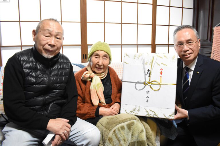 谷口市長から記念品を受け取る片山さん（中央）=岡山県津山市で