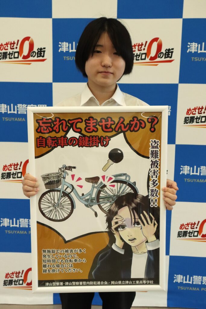 自転車の施錠を啓発するポスターを披露する大前さん