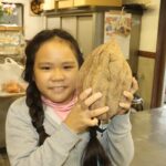 細川さんから大きなサツマイモをもらい喜ぶ松本さん