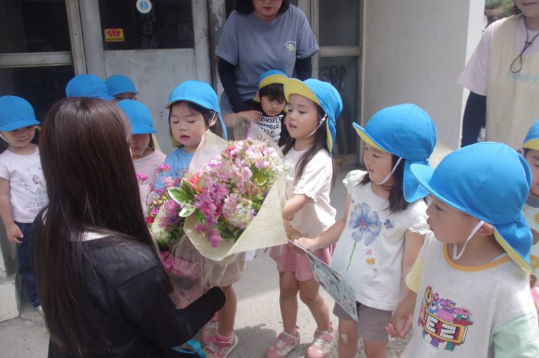 本社を訪れ、花束を手渡す園児たち