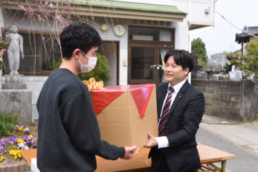 立正青葉学園の子どもたちへ靴を手渡す山田養蜂場の従業員有志＝岡山県津山市で