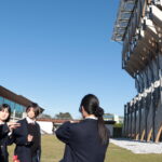 グリーナブルヒルゼンで参加者に地域の見どころを案内する高校生たち＝岡山県真庭市で