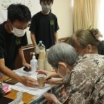 生徒からコーヒーを受け取る入所者