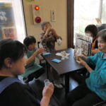 コーヒー牛乳を飲みながら会話を楽しむお年寄り=岡山県津山市で