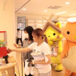 島根県の名産品が当たるガチャガチャをする学生