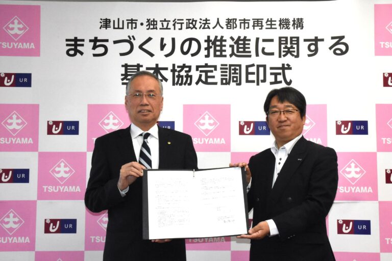 協定書を交わした谷口市長と高原支社長=岡山県津山市で