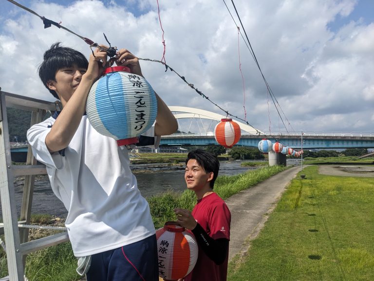 吉井川の河川敷でちょうちんの設置作業をする高校生たち