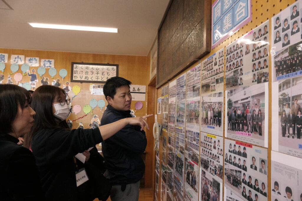 写真を見ながら思い出話に花を咲かせる卒業生ら