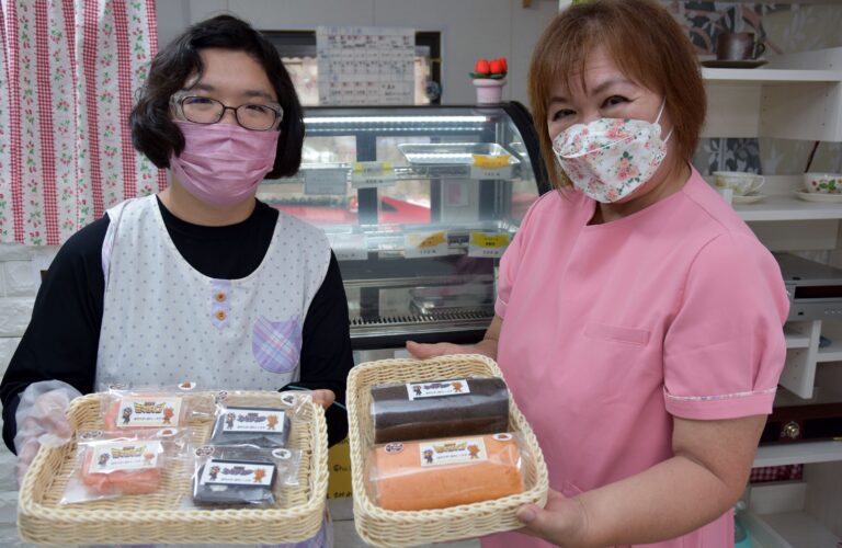 ミマダインロールケーキを手にする平尾所長（右）