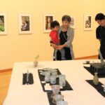 写真や陶芸などの作品に見入る来場者=岡山県勝央町で