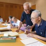 助言を受けながらくずし字の文章を読み解く参加者=岡山県津山市で