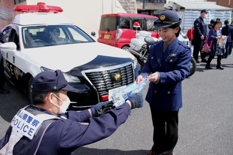 グッズを受け取り、警察官の仕事に理解を深める来場者＝岡山県津山市で