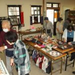 人形や布製品に見入る人々=岡山県真庭市、JR美作落合駅で