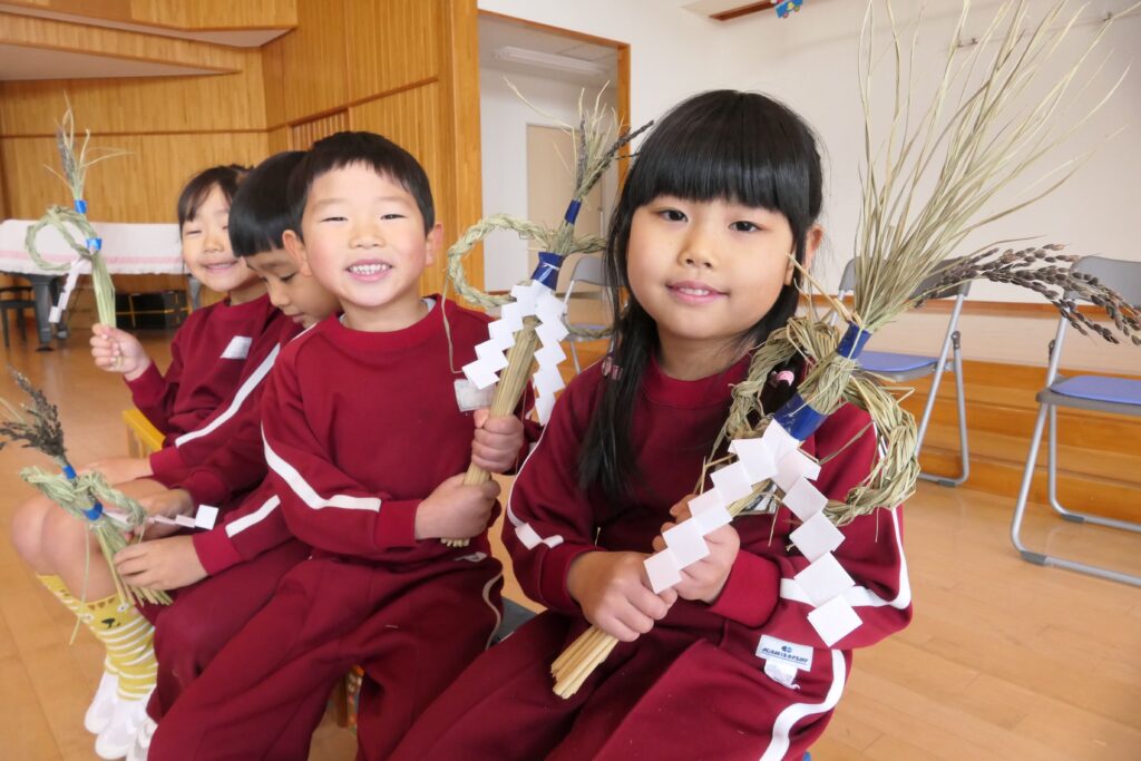 完成したしめ飾りを持つ園児たち=岡山県津山市新野東の勝北風の子こども園で