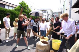 にぎやかにきねを振るうサンタフェの高校生ら=岡山県津山市で