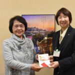 感謝の気持ちを込めて図書館に寄付をした小野田さん（左）=岡山県津山市で