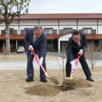 苗木に土をかぶせる小倉村長（左）と坂本議長=岡山県新庄村で