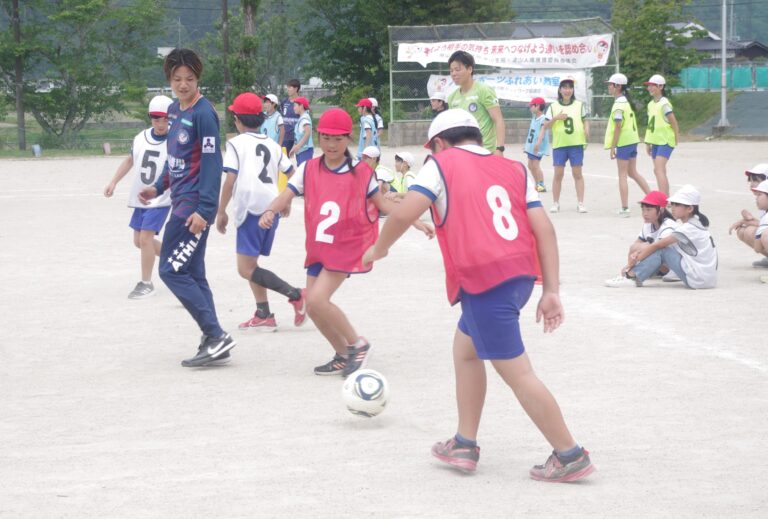 岡山湯郷ベルの選手にアドバイスをもらいながらサッカーを楽しむ子どもたち=岡山県真庭市で