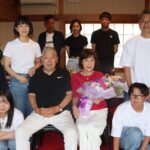 家族に囲まれ祝福される立石さん（前列右から2番目）=岡山県津山市で