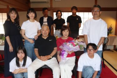 家族に囲まれ祝福される立石さん（前列右から2番目）=岡山県津山市で