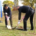 ハナモモの苗木を植樹する鳥越会長（左）と谷口市長=岡山県津山市で