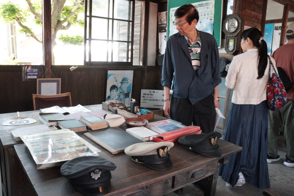 展示されている駅員ゆかりの道具などを眺める乗客＝美作滝尾駅で
