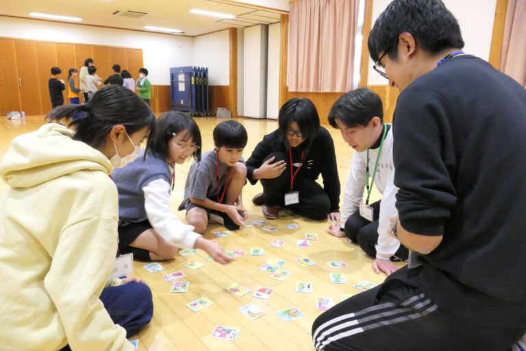 美作大学の学生と昔遊びを楽しむ小学生たち=岡山県津山市で