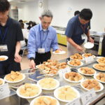 津山産小麦で製造されたパンを試食する参加者=岡山県津山市で