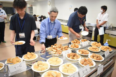 津山産小麦で製造されたパンを試食する参加者=岡山県津山市で