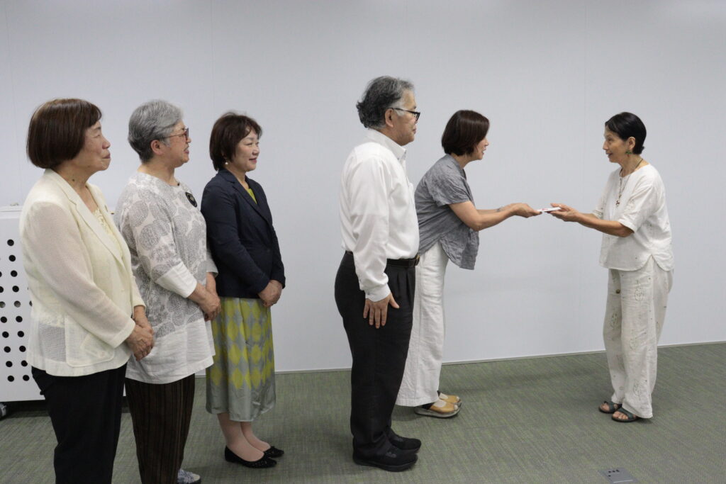 市場さん(右)に寄付金を手渡す芦田会長