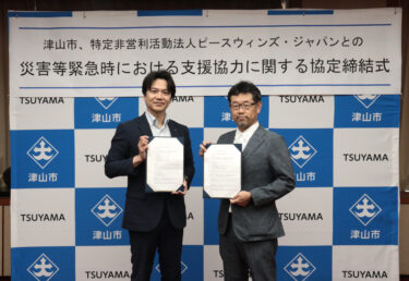 災害時の支援協力に関する協定書を手にする光井市長（左）と稲葉医師＝岡山県津山市で