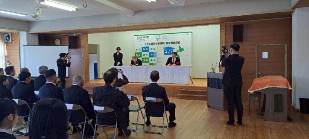 協定書に署名する水嶋町長(左)と菅原理事長