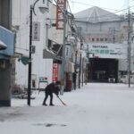 雪かきをする人=8日午前7時26分