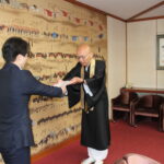 光井市長に委嘱状を交付する守安理事長＝岡山県津山市で