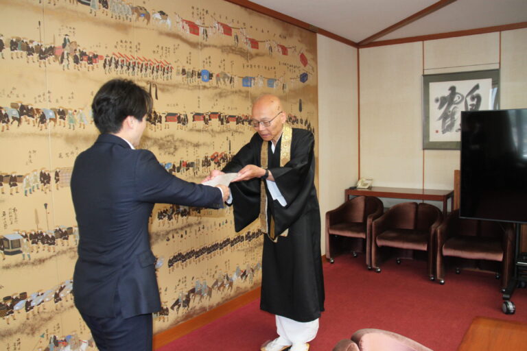 光井市長に委嘱状を交付する守安理事長＝岡山県津山市で