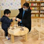 子育て支援コーナーの木育玩具で遊ぶ親子=岡山県津山市で