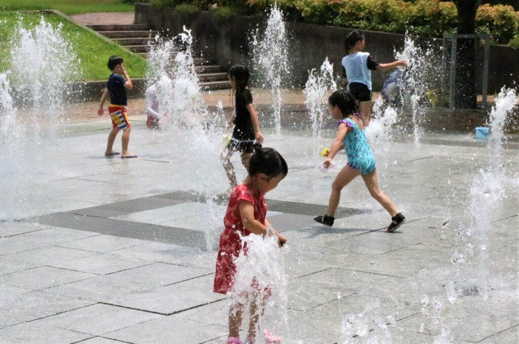 噴水の水を浴びながら涼を満喫する子どもたち