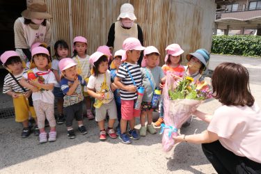 田町保育園（田町）の園児たち キリスト教の花の日（６月第２日曜日）にちなみ、周辺の事業所に花束を贈る