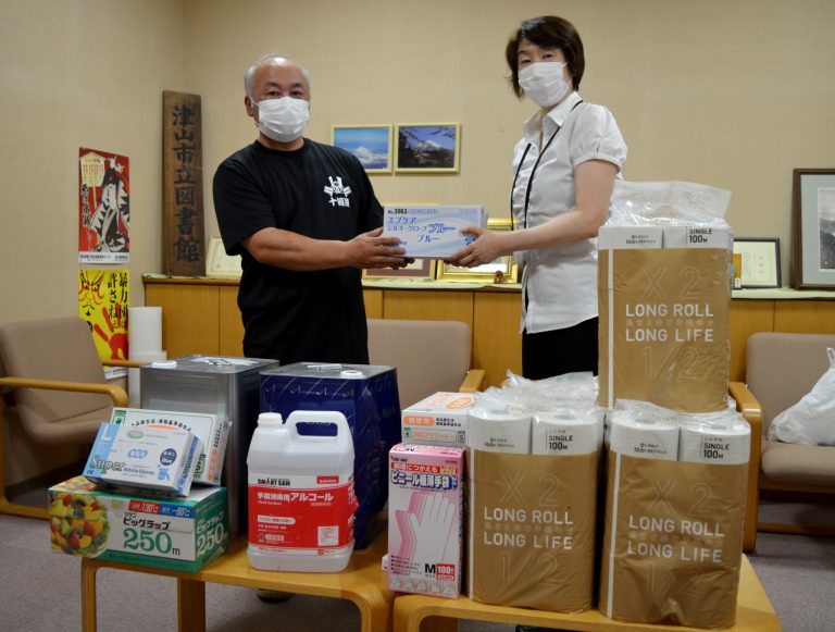 岡山県津山市立図書館に感染対策用品を贈る安富さん（左）