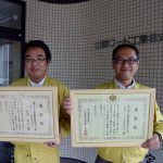 表彰状を手にする秋田社長（右）と監理技術者の丸内さん