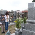 墓に手を合わせる市民＝妙法寺で