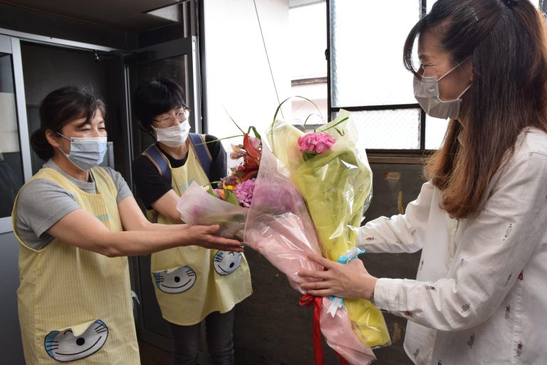 本社を訪れ、手作りの花束を渡す田町保育園の職員
