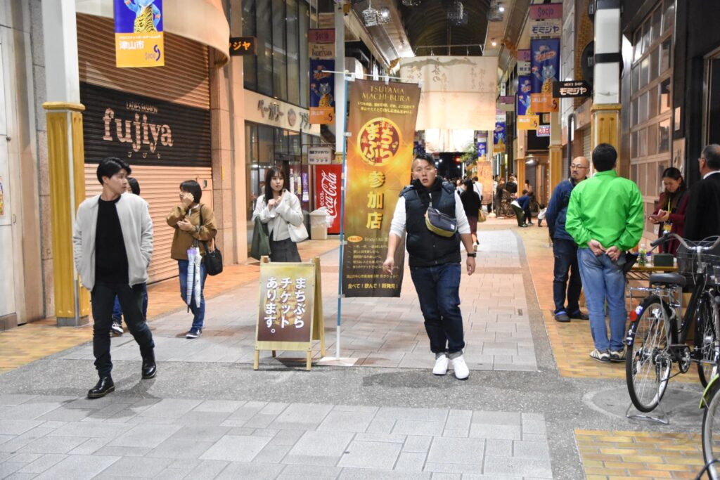 地図とチケットを片手に商店街の散策を楽しむ来場者