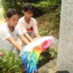 慰霊塔に千羽鶴を供える児童たち=岡山県津山市で