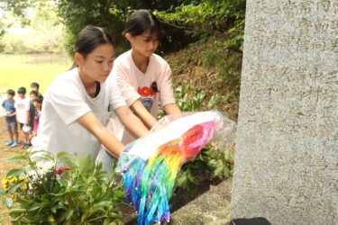 慰霊塔に千羽鶴を供える児童たち=岡山県津山市で