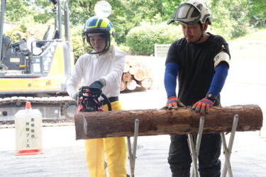 指導を受けながらチェーンソーで丸太を切る参加者＝岡山県勝央町で
